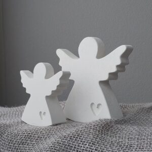 Seitliche Ansicht eines grossen weissen Betonengels mit Herzgravur