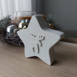 Weisser Betonstern mit Elch Gravur in seitlicher Perspektive