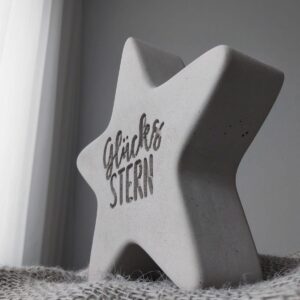 Detailaufnahme der Gravur „Glücksstern“ auf einem Betonstern