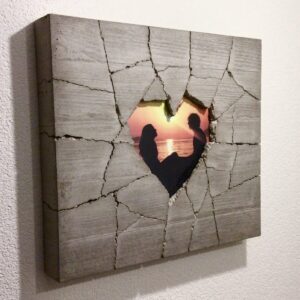 Seitliche Ansicht eines handgefertigten Betonbildes mit gebrochenem Herzrahmen und persönlichem Foto