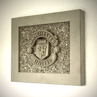 Seitliche Ansicht eines handgefertigten Manchester United Betonbilds mit 3D-Relief
