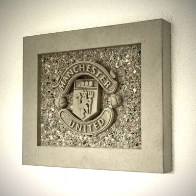 Seitliche Ansicht eines handgefertigten Manchester United Betonbilds mit 3D-Relief